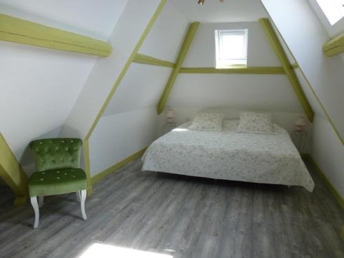 - une chambre avec un lit et une chaise verte dans l'établissement Villa D'ALBATRE, à Dieppe