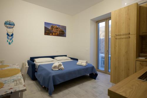 a bedroom with a blue bed with towels on it at Danys home in Ischia Town