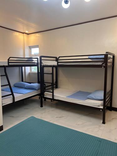 three bunk beds in a room with a rug at Casa Villa Gracia in Bigaa