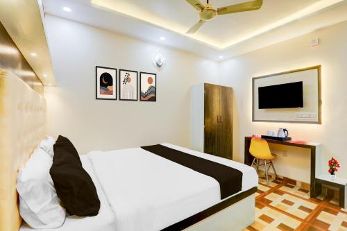 a bedroom with a bed and a desk and a tv at Collection O Jagdeo Path Patna in Patna
