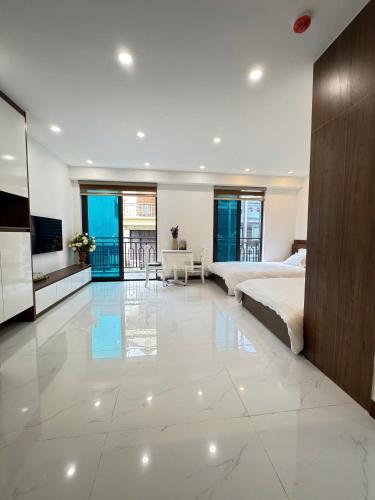 a large bedroom with a bed and a television in it at Fuji Apartment in Hanoi