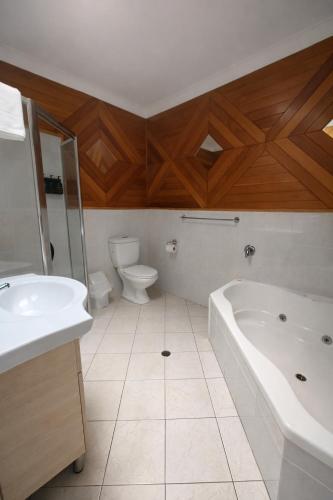 a bathroom with a tub and a toilet and a sink at Hahndorf Motel in Hahndorf
