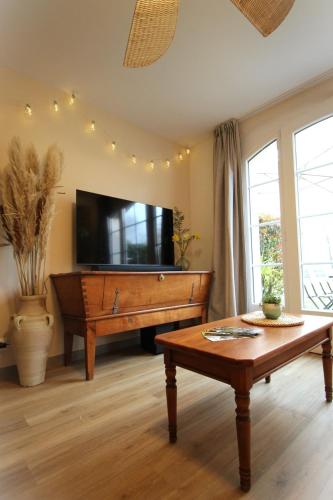 a living room with a piano and a table at Maison cosy 6 pers - piscine chauffée - nature et lac - Monflanquin in Monflanquin