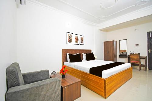 a bedroom with a bed and a couch and a chair at Super Collection O Raja Bazar Bailey Road in Patna