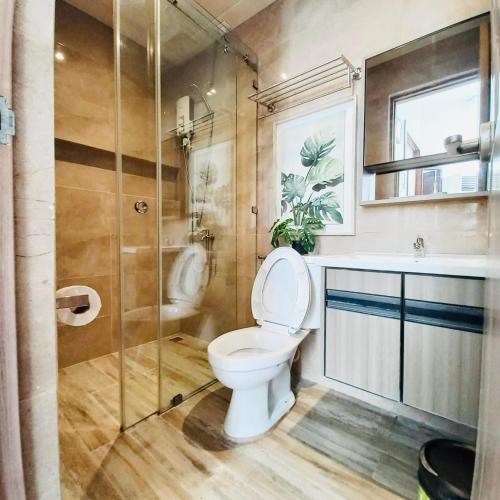 a bathroom with a toilet and a glass shower at Summer in Lapu Lapu City
