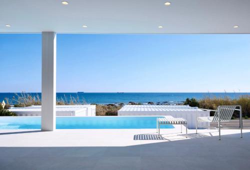 a swimming pool with two chairs and a view of the ocean at UMInoTERRACE in Minamiboso