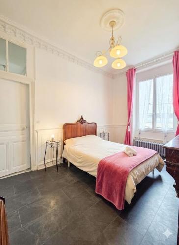 a bedroom with a bed with a red blanket on it at Appart de charme, centre Vichy, Thermes in Vichy