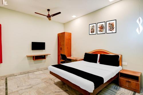 a bedroom with a bed and a desk and a tv at Collection O Vadapalani Formerly Mahalakshmi Inn in Chennai