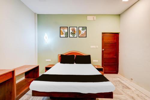 a bedroom with a bed and a wooden cabinet at Collection O Vadapalani Formerly Mahalakshmi Inn in Chennai