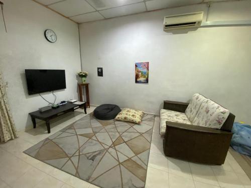 a living room with a couch and a flat screen tv at Homestay 3U MU5L1M Only in Cukai