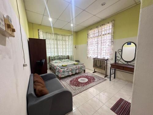 a living room with a couch and a bed and a mirror at Homestay 3U MU5L1M Only in Cukai