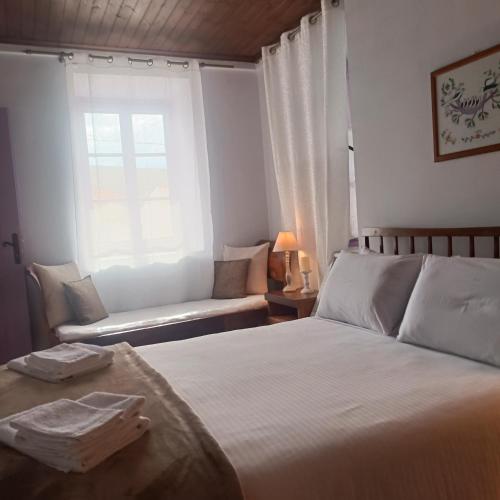 a bedroom with a bed and a window and a couch at Oianthis house in Galaxidi