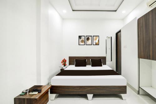 a bedroom with a large bed and a wooden table at Collection O Ujjain City Centre Formerly Hotel Olive Inn in Ujjain