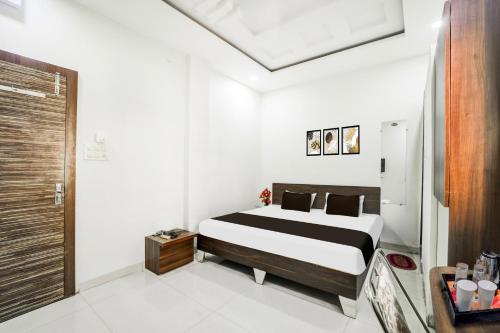a bedroom with a black and white bed in a room at Collection O Ujjain City Centre Formerly Hotel Olive Inn in Ujjain