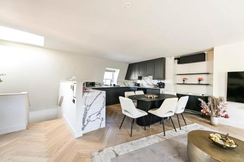 a kitchen and living room with a table and chairs at Luxury Apartments in Marylebone Village in London