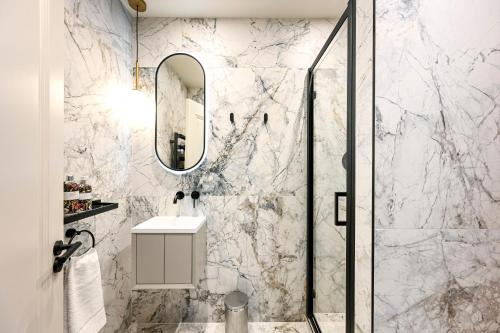 a bathroom with a shower with a sink and a mirror at Luxury Apartments in Marylebone Village in London