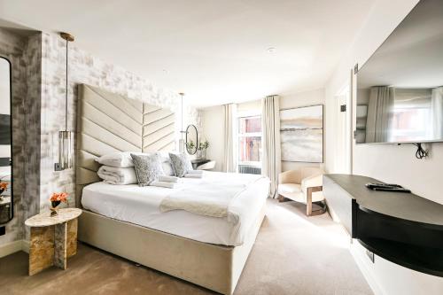 a bedroom with a large white bed and a desk at Luxury Apartments in Marylebone Village in London