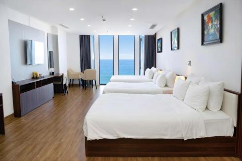 two beds in a hotel room with a view of the ocean at DAO NGOC BEACH HOTEL Da Nang in Danang