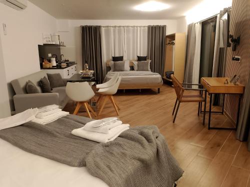 a bedroom with a bed and a living room with a couch at Rafina Studio apartments kondilia in Rafina