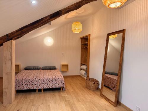 a bedroom with a bed and a large mirror at Confort et élégance au cœur de Florac in Florac