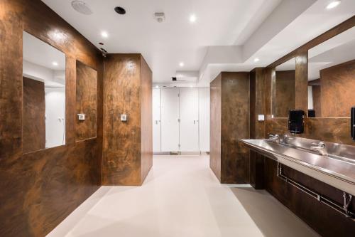 un bagno con pannelli in legno e lavandini e un corridoio di City Hostel a Stoccolma