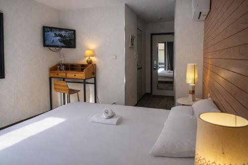 a bedroom with a large white bed and a bathroom at Enzo Hôtels - ST Eloy Metz Amneville in Amnéville