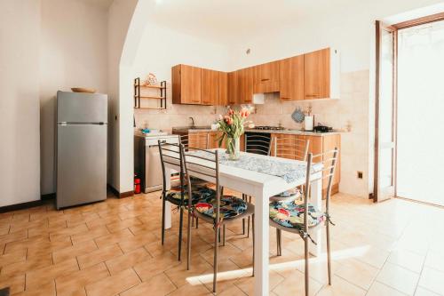 a kitchen with a table and chairs and a refrigerator at Appartamento Ortensia - Meina in Meina