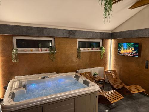 a large soaking tub in a room with chairs at Bungalovy CLASSIC & Wellness Podhájska - Adults Only in Podhájska