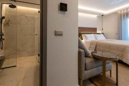 ein Schlafzimmer mit Bett, Dusche und Stuhl in der Unterkunft Vivere Suites in Nafplio