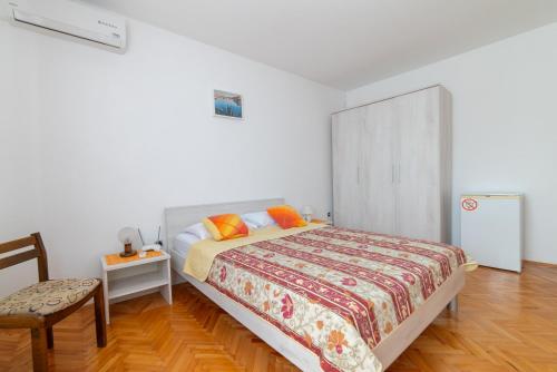 a bedroom with a bed and a table and a chair at Nikola's spacious apartment in Božava