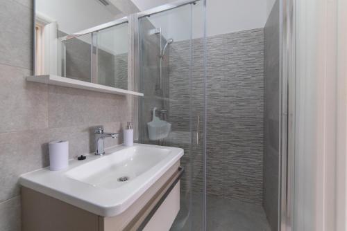 a bathroom with a sink and a glass shower at Nikola's spacious apartment in Božava