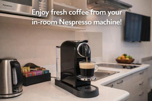 a coffee maker on a kitchen counter with a cup of coffee at Gilmer Apartment Hotel in Wellington