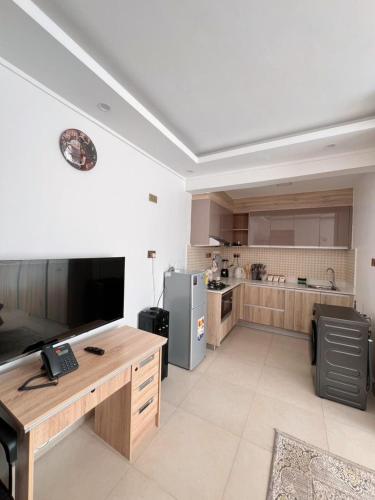 a large kitchen with a desk and a refrigerator at Sharz Cozy studio - Westlands in Nairobi