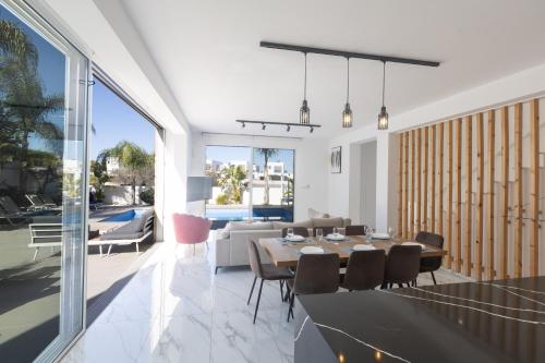 a dining room and living room with a table and chairs at Vie Bleu Villas in Protaras