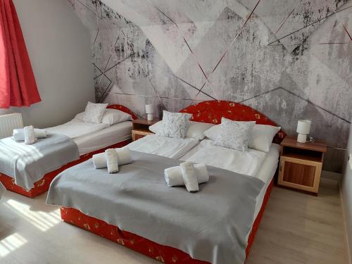 two beds in a room with a mural at Norbert Vendégház in Balatonszárszó