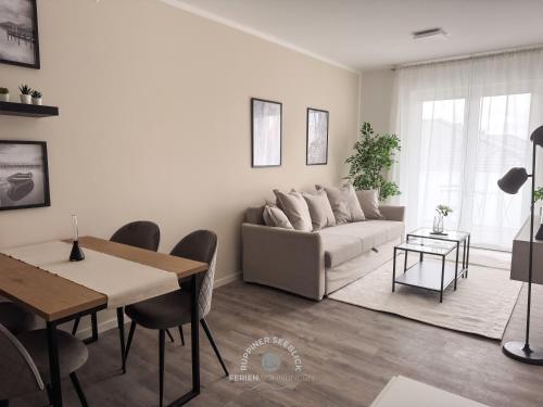 a living room with a couch and a table at Ruppiner Seeblick Ferienwohnungen in Neuruppin