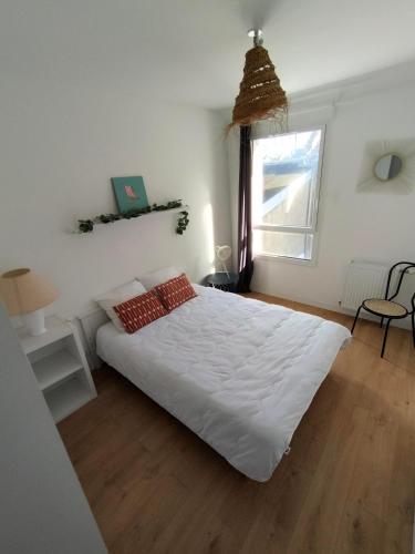 a bedroom with a large white bed and a window at Ptit salé Quiberon in Quiberon