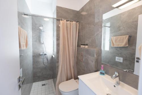 a bathroom with a shower and a toilet and a sink at Vie Bleu Villas in Protaras