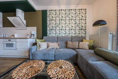 a living room with a blue couch and a kitchen at Comfort Apartments Batorego in Gdynia