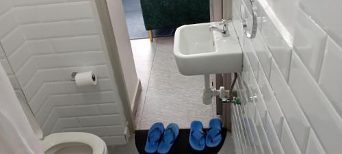 a bathroom with a toilet and two blue slippers at Starla, Duplex in Nairobi
