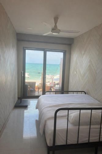 a bedroom with a bed and a view of the ocean at Moonrise Beachfront Luxury in Nathon Bay