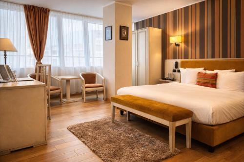 a hotel room with a large bed and a desk at Hotel Paradis in Cluj-Napoca