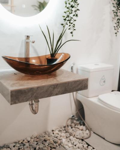 a bathroom with a wooden bowl sink on a counter at Balay nimo by Sachzna in Amadeo