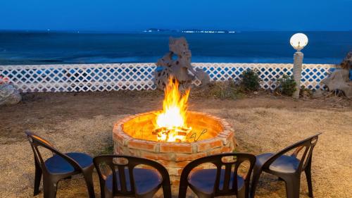 a fire pit with chairs and the ocean in the background at Taean Tteulapbada Pension in Taean