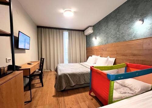 a hotel room with a bed and a desk and a tv at St George Ski & Holiday - Half Board & All Inclusive in Bansko