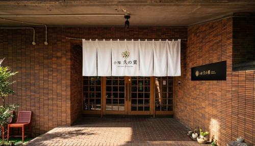 a brick building with a door with a curtain on it at Kozuka Hisanoha in Hakone