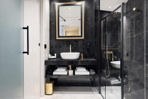 a bathroom with a sink and a glass shower at The Unique Hotel Brera in Milan