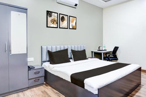 a bedroom with a large bed and a desk at Super Collection O Pashan-Sus Road Baner Formerly Grey Stone in Pune