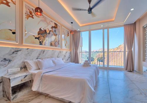 a bedroom with a large bed and a large window at Hill Breeze Pool Resort Vagamon by VOYE HOMES in Vagamon
