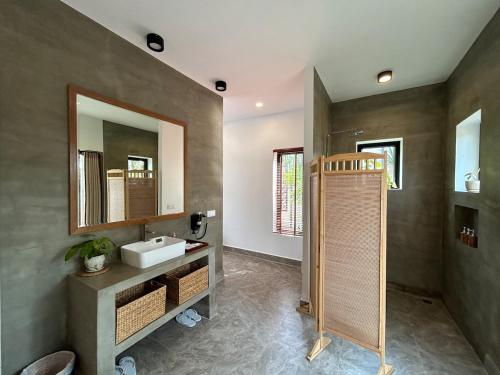 a bathroom with a sink and a mirror at Private Bungalow, Large Salt Water Pool & Jacuzzi, Super Fast WIFI 100Mbps in Phumĭ Kruŏs